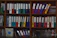 A neatly arranged office corner featuring a wooden bookcase filled with colorful binders and plants.