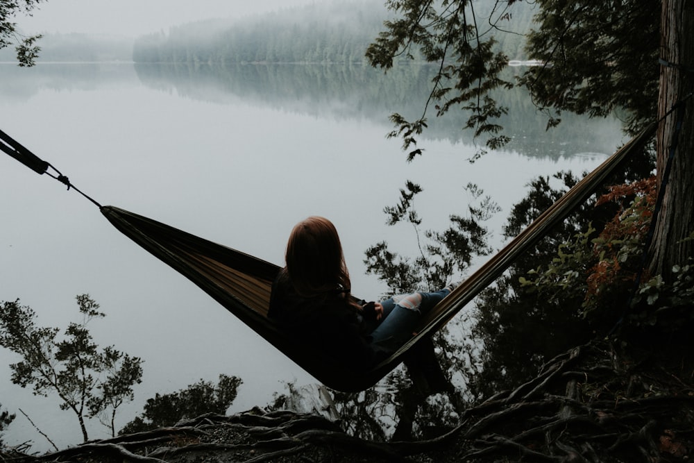 woman sitting on hammock while facing backwards