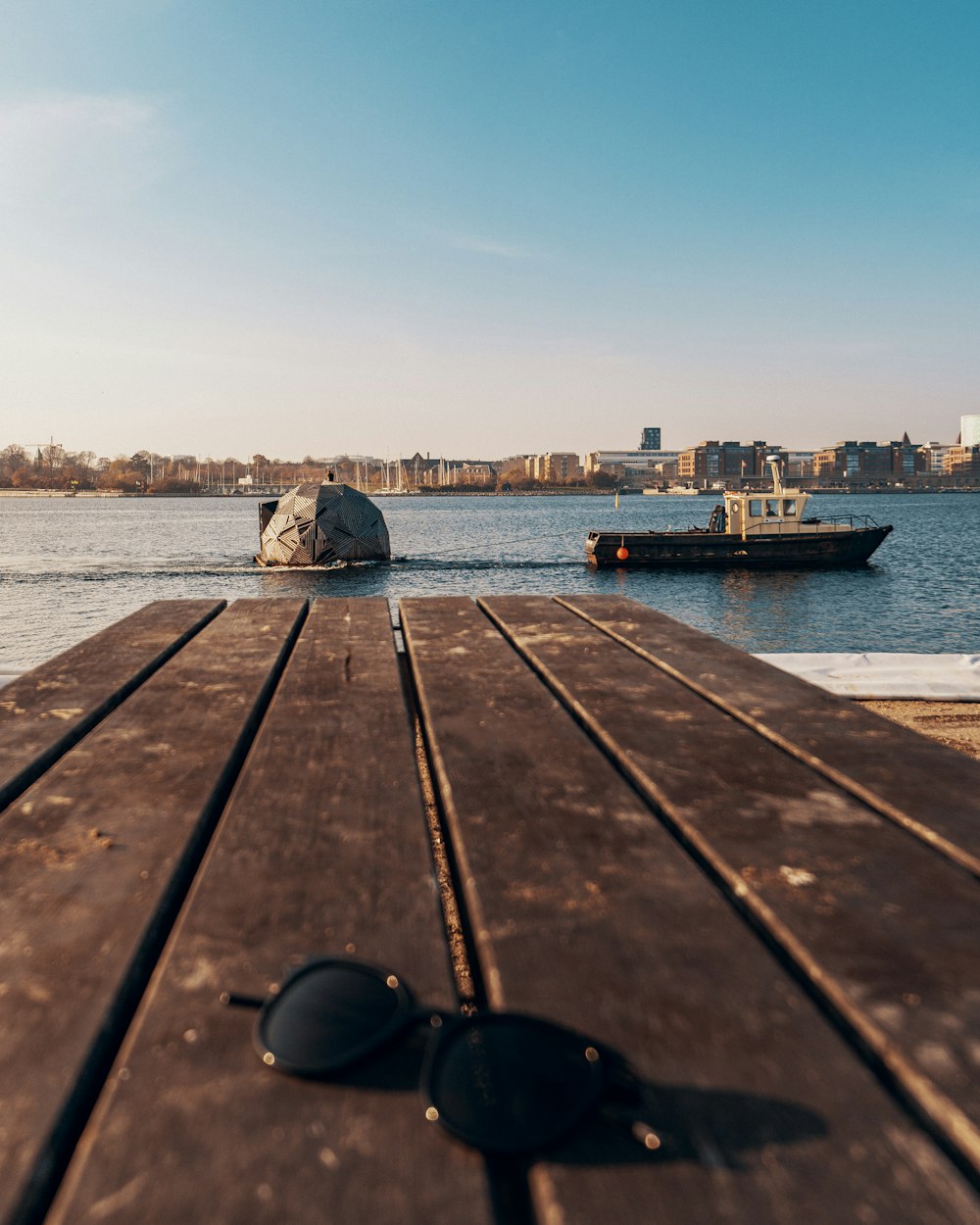 Gafas de sol con montura negra sobre superficie de madera marrón