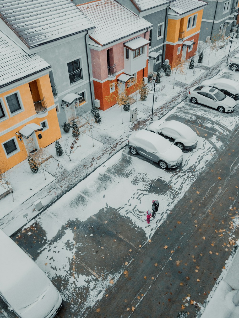 aerial photography of snow covered cars parked beside house