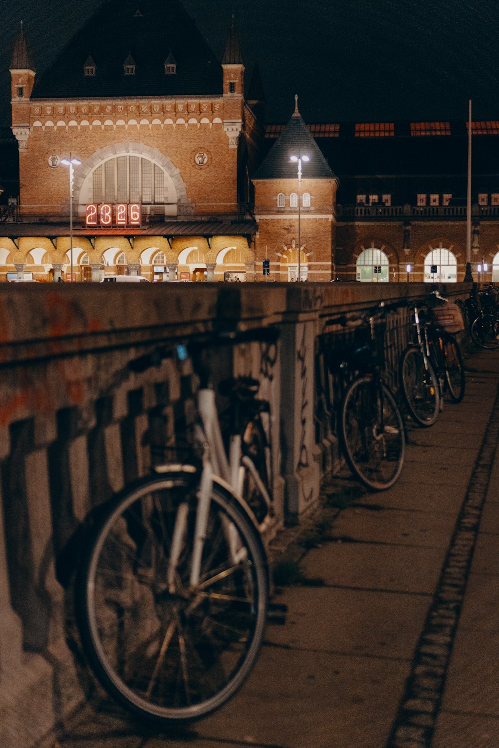 bicycles parked beside concrete railing at night