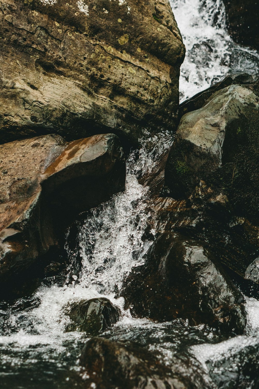 waterfalls in the middle of brown rocks