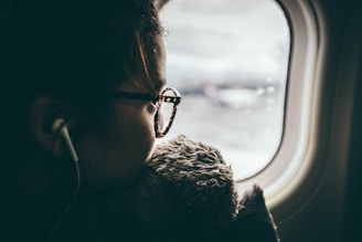 woman wearing eyeglasses riding a plane