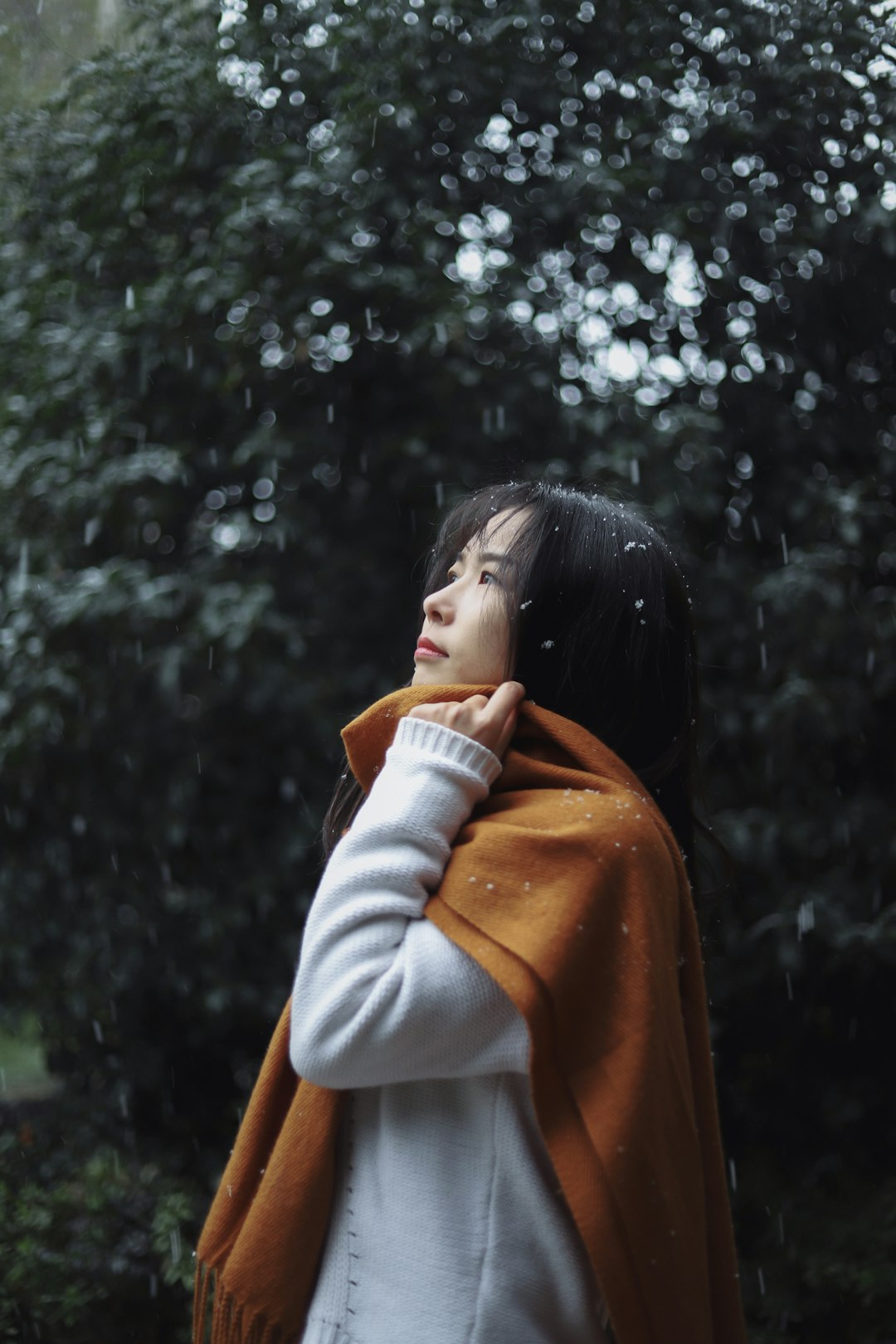 woman wearing white sweater and orange fringe scarf during daytime