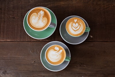 three ceramic mugs with latte cup teams background