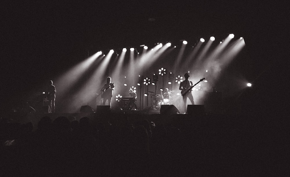 Fotografía en escala de grises de la banda tocando en el escenario
