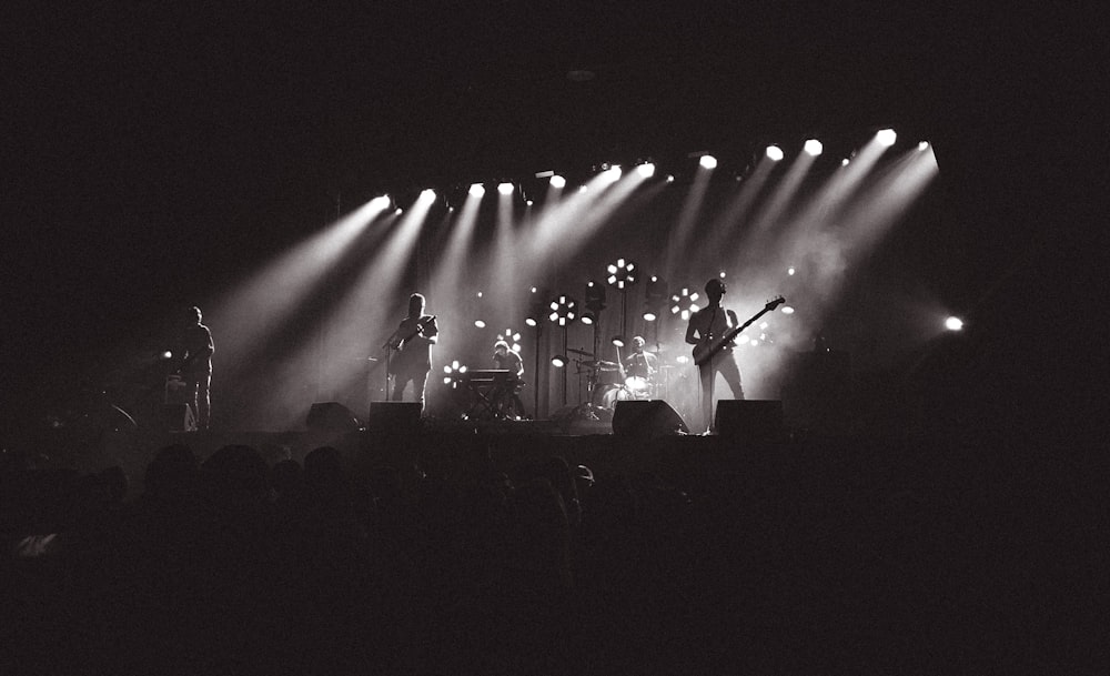 grayscale photography of band performing on stage