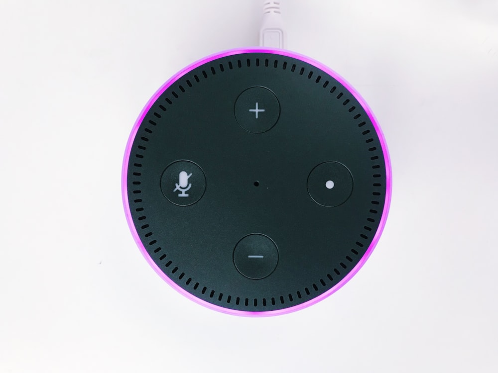 Amazon Echo Dot negro y púrpura de 2.ª generación sobre superficie blanca