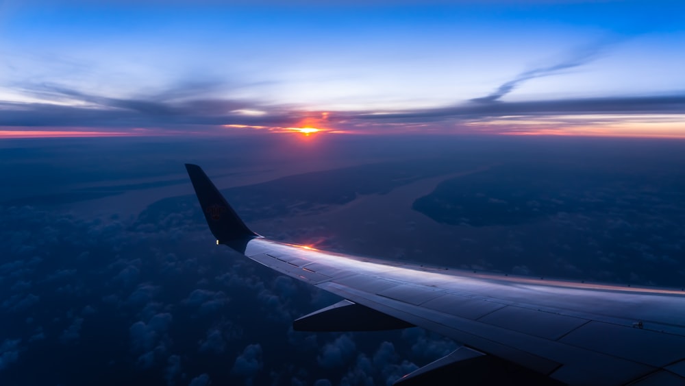 plane flying over countryside at sunset