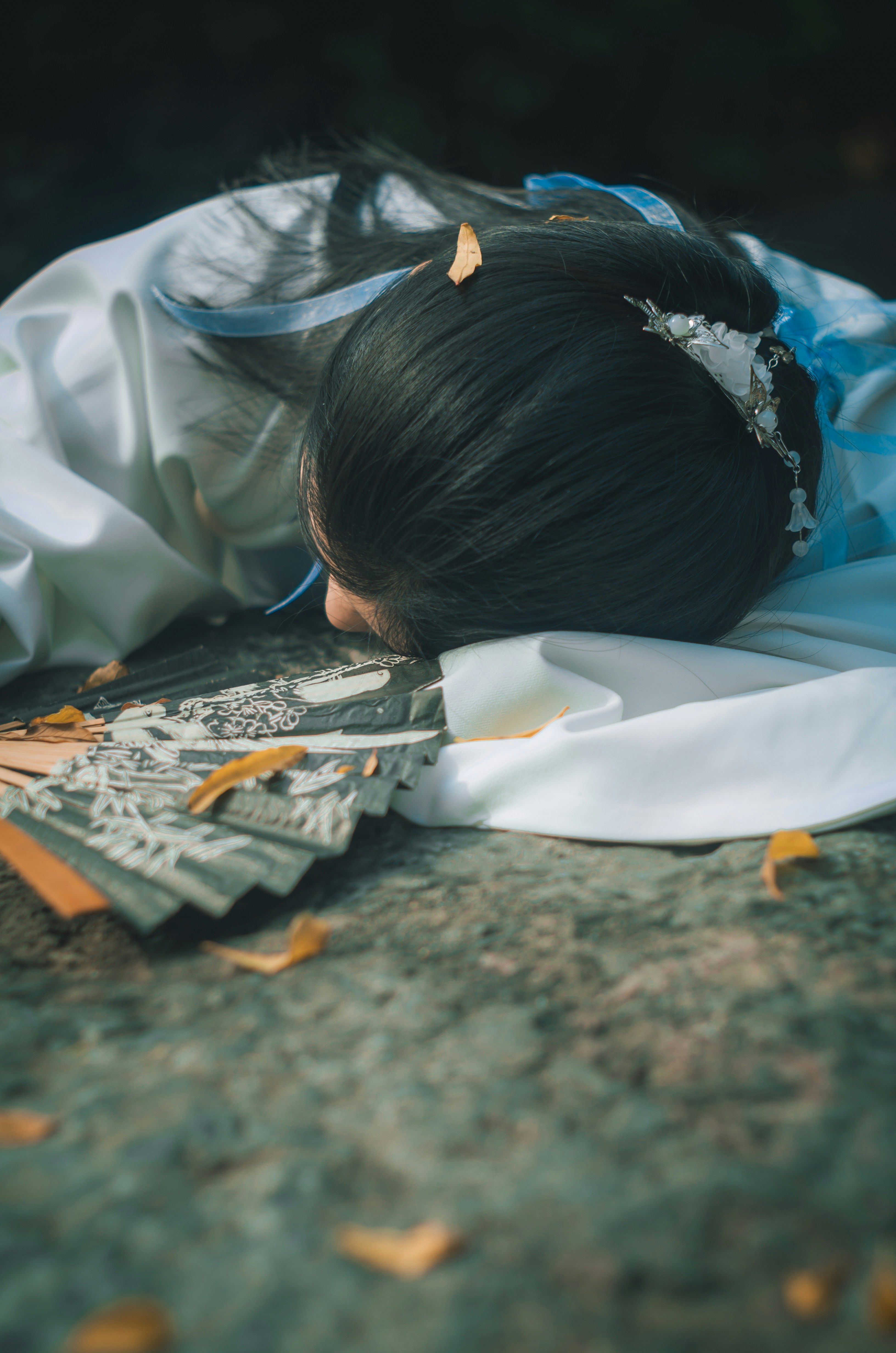 Wanita berbaju teal berbaring telungkup di lantai