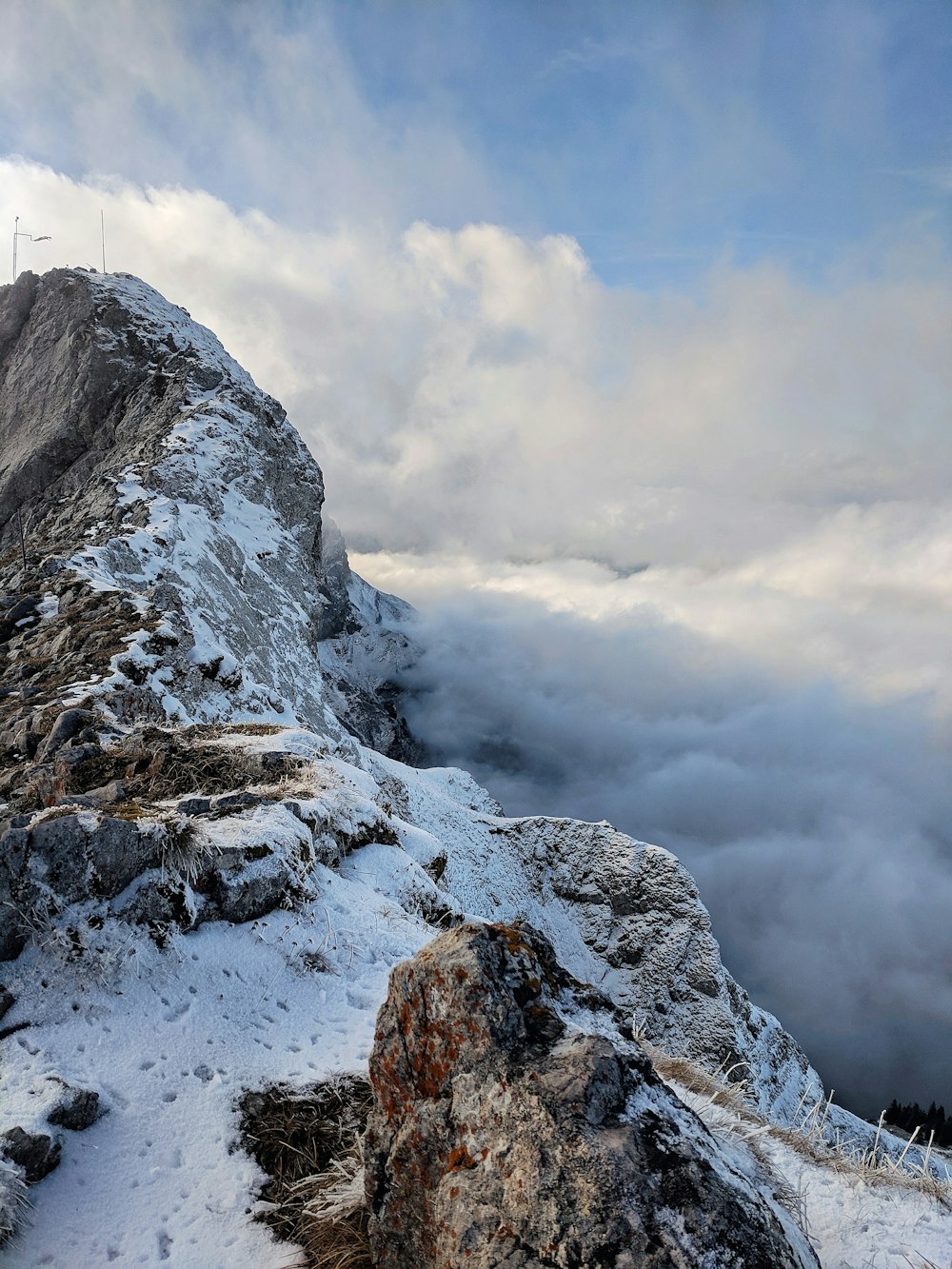 snow covered hill near clouds at daytime