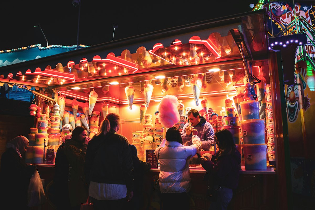 Promeneurs devant un stand gourmand illuminé, un soir d'hiver à Londres