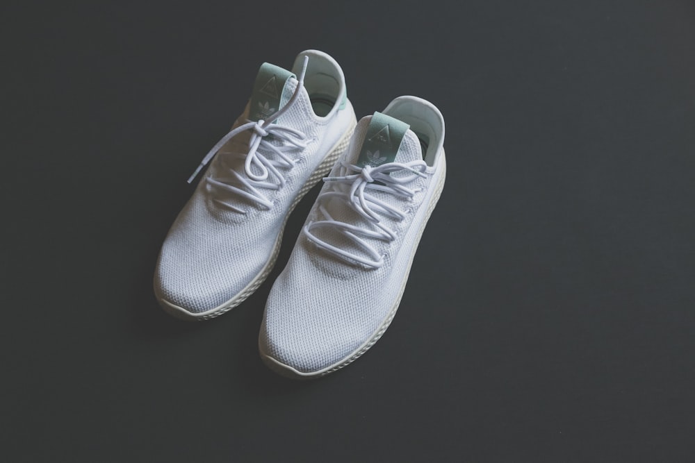 pair of white adidas sneakers