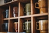 assorted-color ceramic mug on the shelf