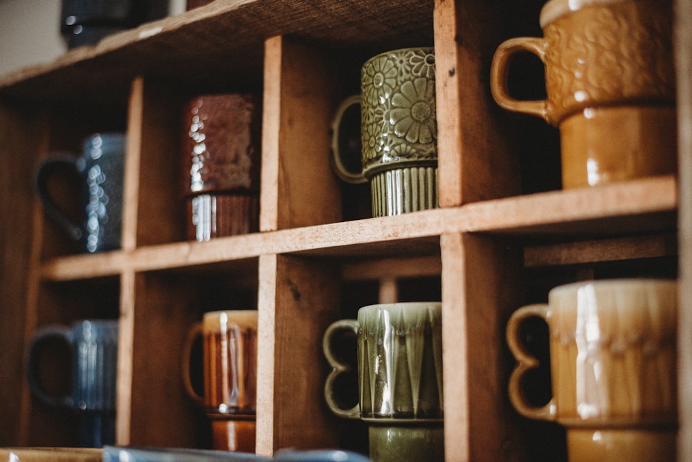 assorted-color ceramic mug on the shelf