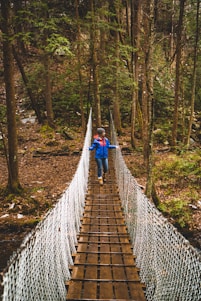 woman crossing brown bridge