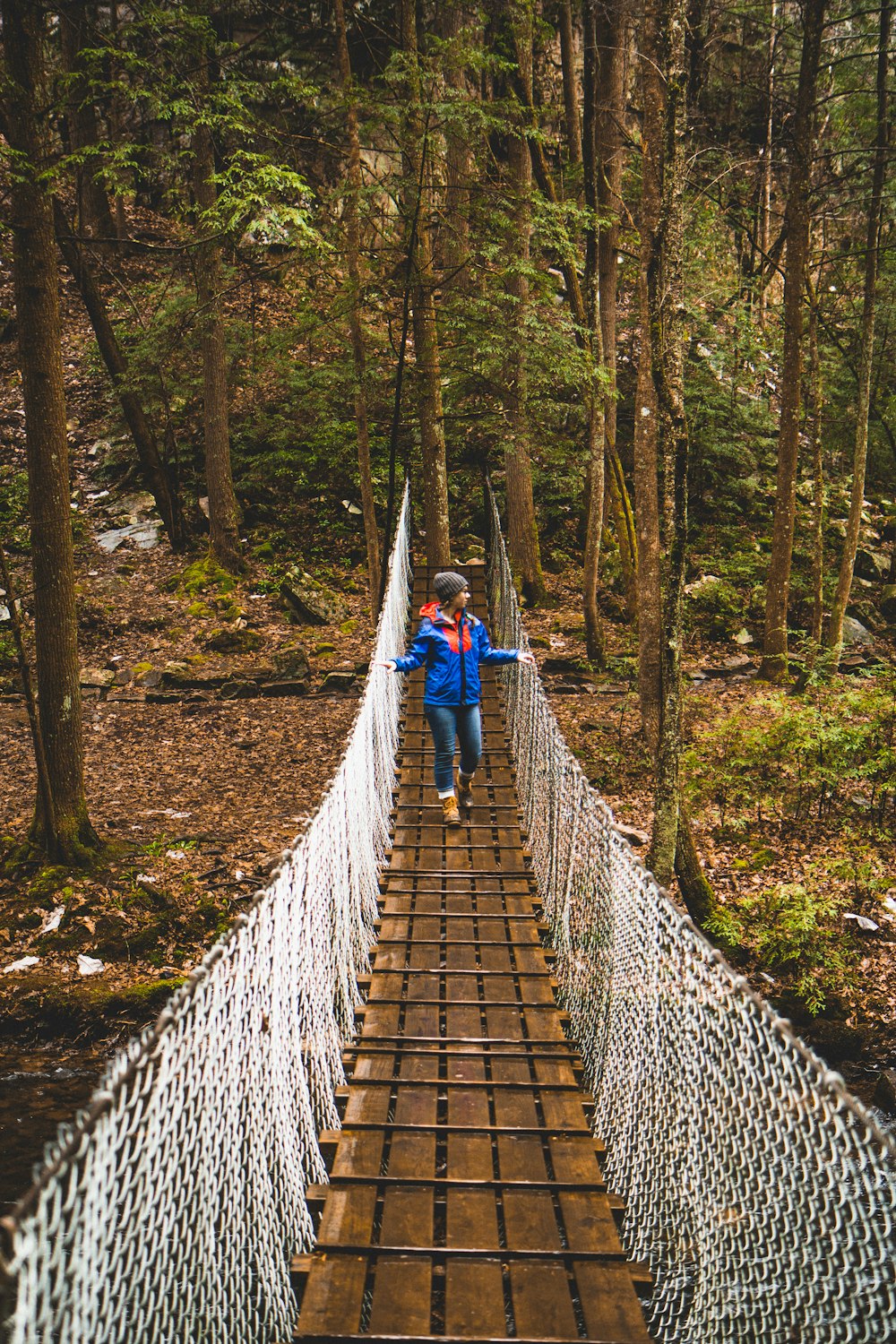 woman crossing brown bridge