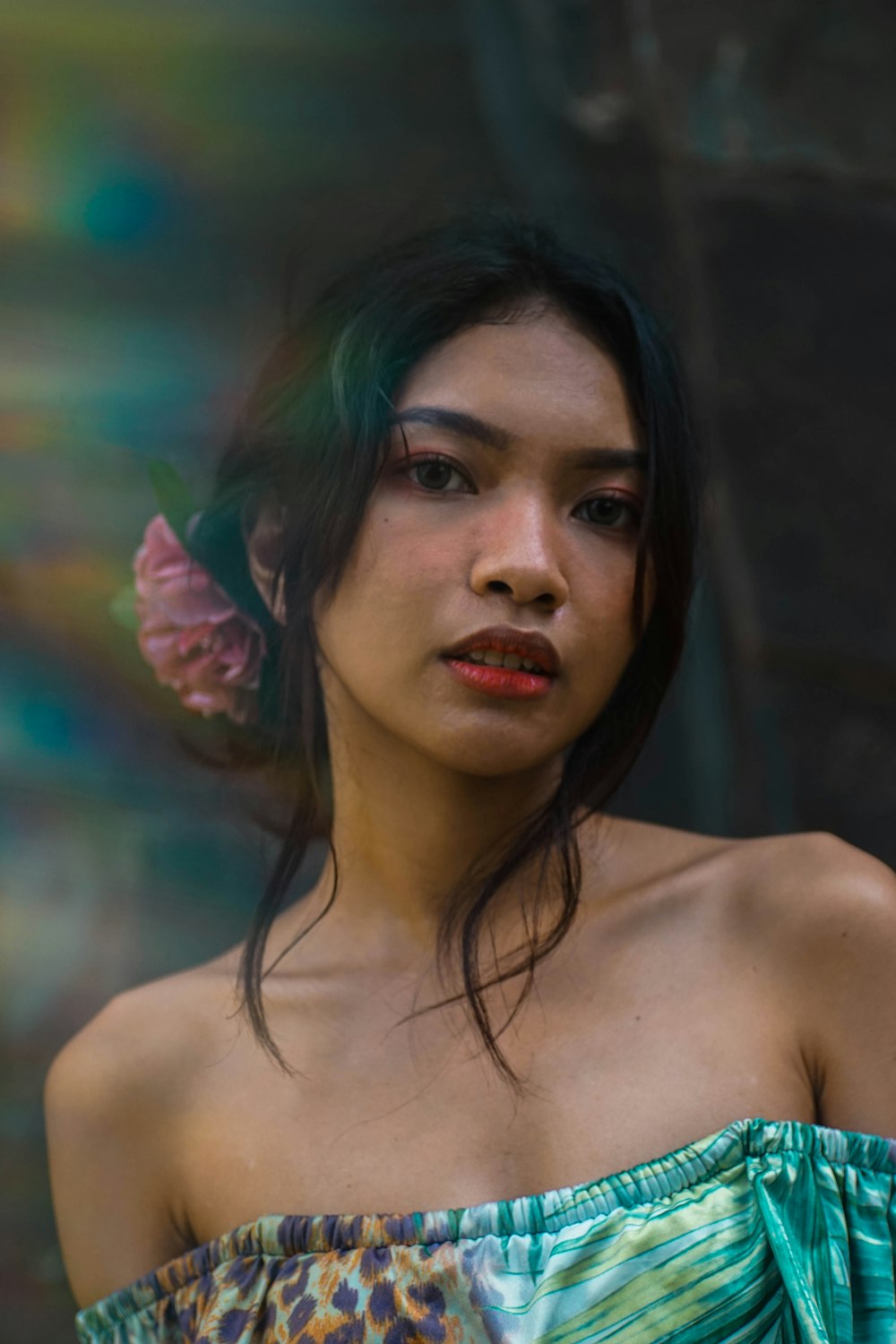 woman with red flowers on her ear