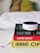 A small Amazon Echo device is placed on top of a stack of three books. The titles visible are 'Shoe Dog', 'Hacking Growth', and 'Humans', each with distinctive colors and fonts. The books are neatly stacked on a white surface, and in the background, a blurred, cozy-looking white and yellow pillow or blanket is visible.