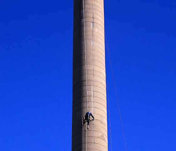 A friendly technician in uniform cleaning a chimney on a sunny day in Winter Haven.