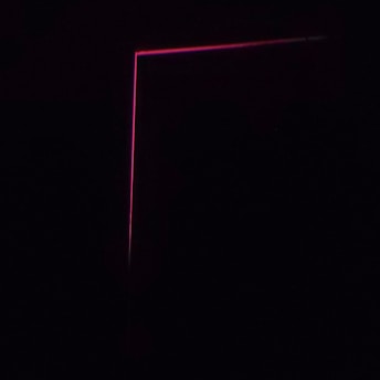 A dark background with a thin, pink neon line forming an L-shape, creating a minimalist and modern aesthetic.