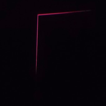 A dark background with a thin, pink neon line forming an L-shape, creating a minimalist and modern aesthetic.