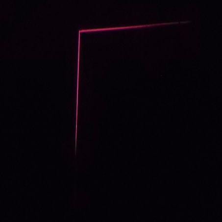 A dark background with a thin, pink neon line forming an L-shape, creating a minimalist and modern aesthetic.