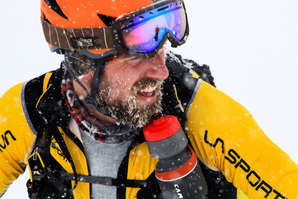 man wearing orange and black snow goggles