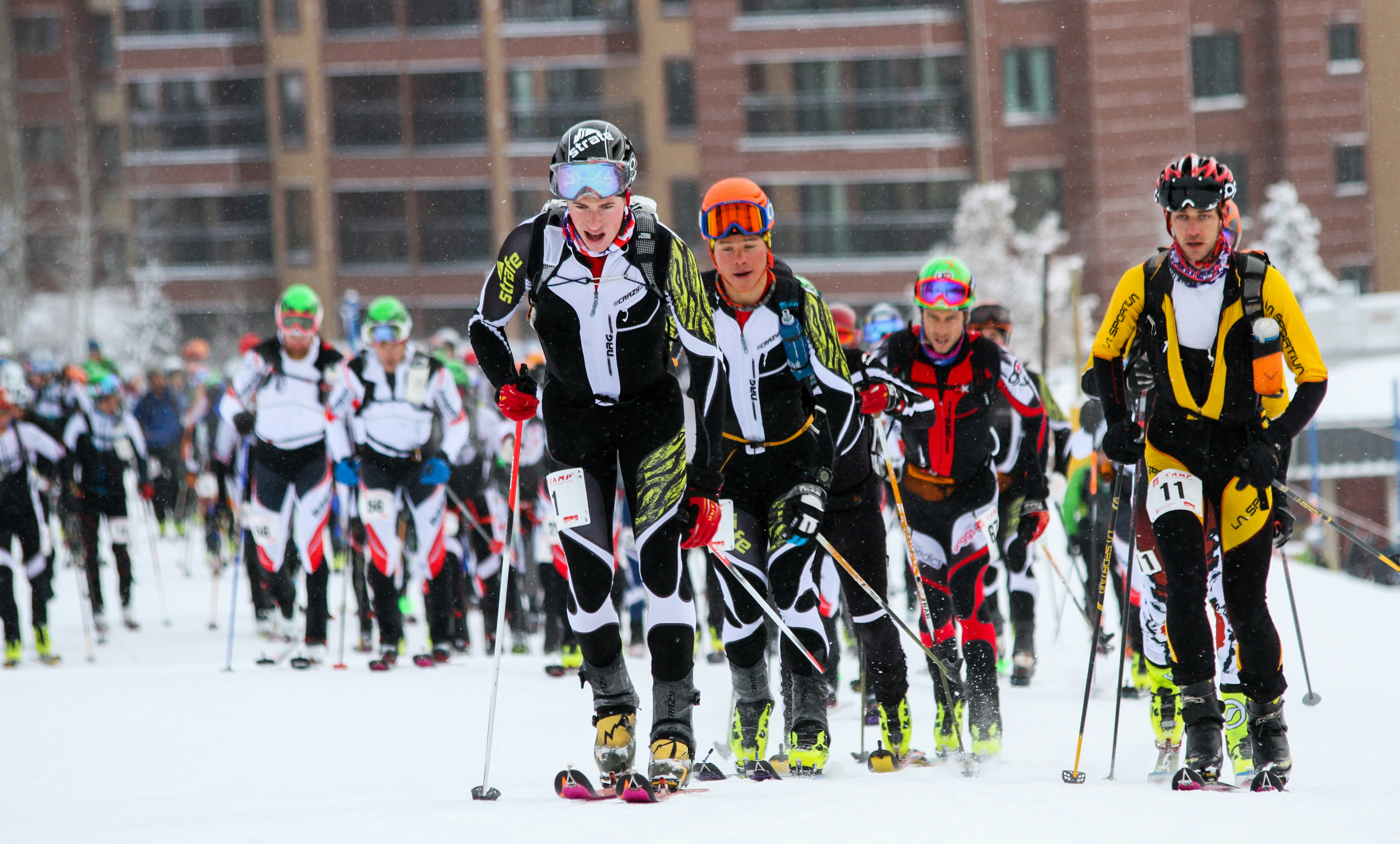 A photo of the beginning of a skimo race, just after the racers have left the start line.