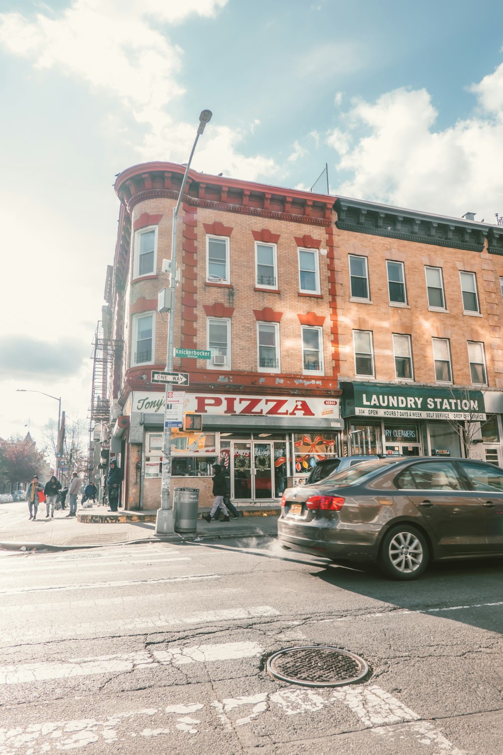 gray sedan beside pizza store