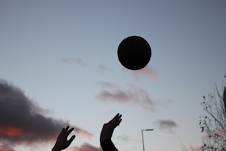 Capturing the tense moment of a bowler mid-run-up delivering the ball under the night sky.
