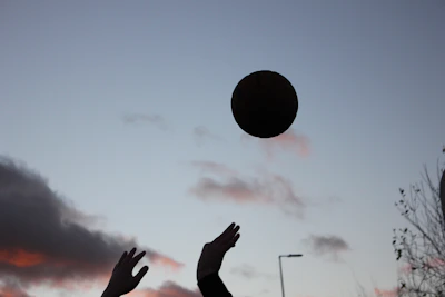 High-contrast silhouette of a player executing a perfect volley against a dramatic sunset sky.
