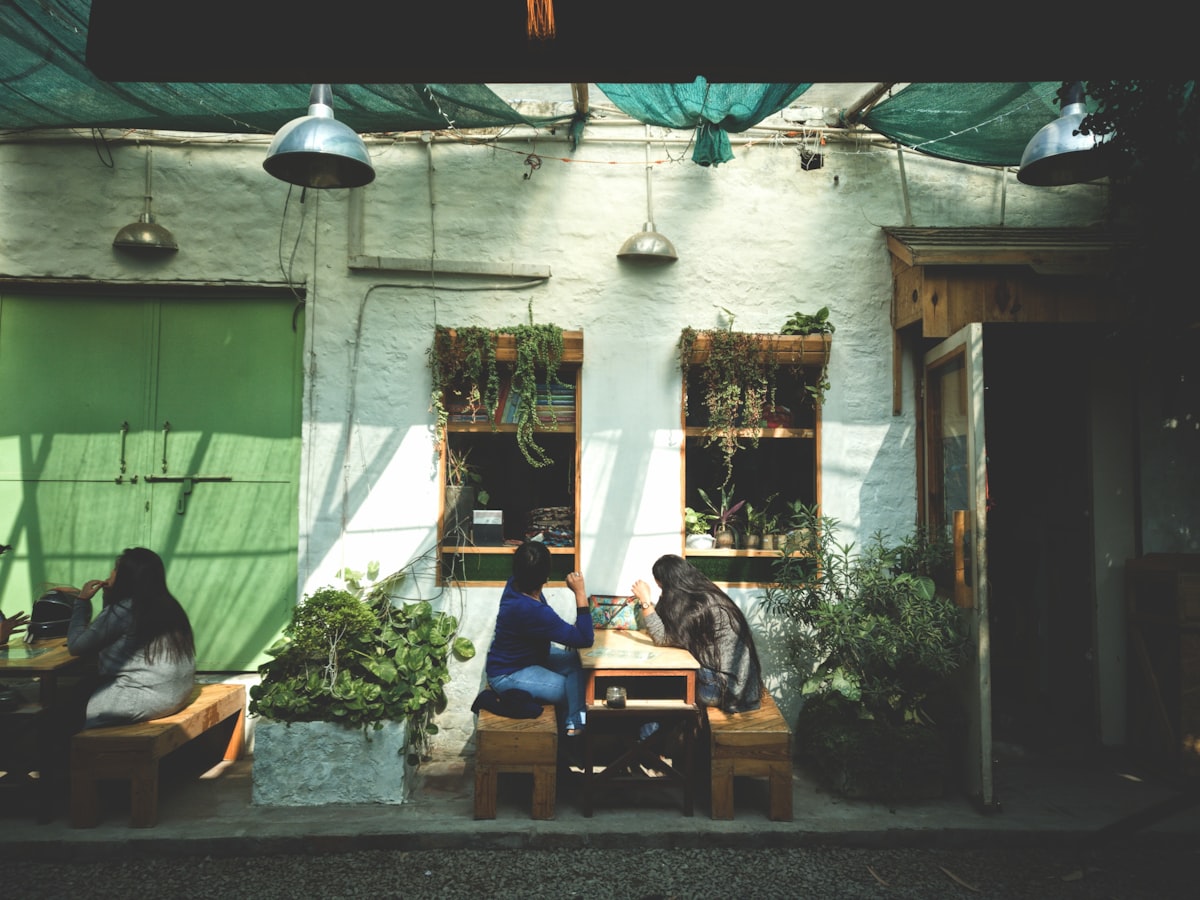 Two people sitting face to face at an outdoor coffee shop, a sober daytime date