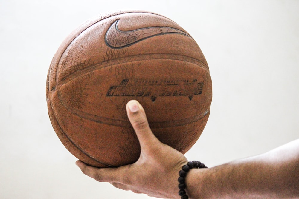 person holding brown Nike basketball