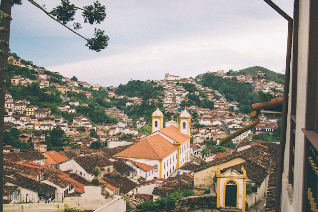 A vibrant panoramic view of Sugamuxi’s rolling green hills and colonial architecture under a bright blue sky.