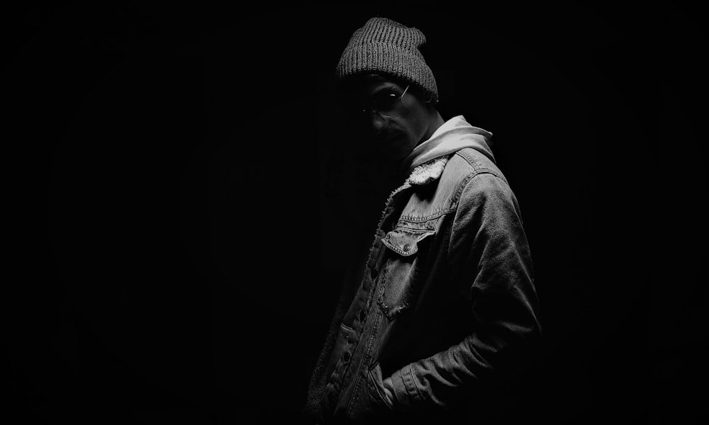 man wearing cap and jacket grayscale photo