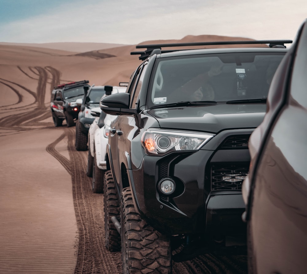 black SUV running on dune san