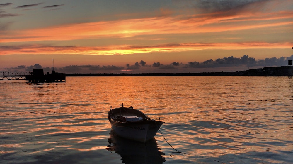 gray and brown canoe at beach during sunset