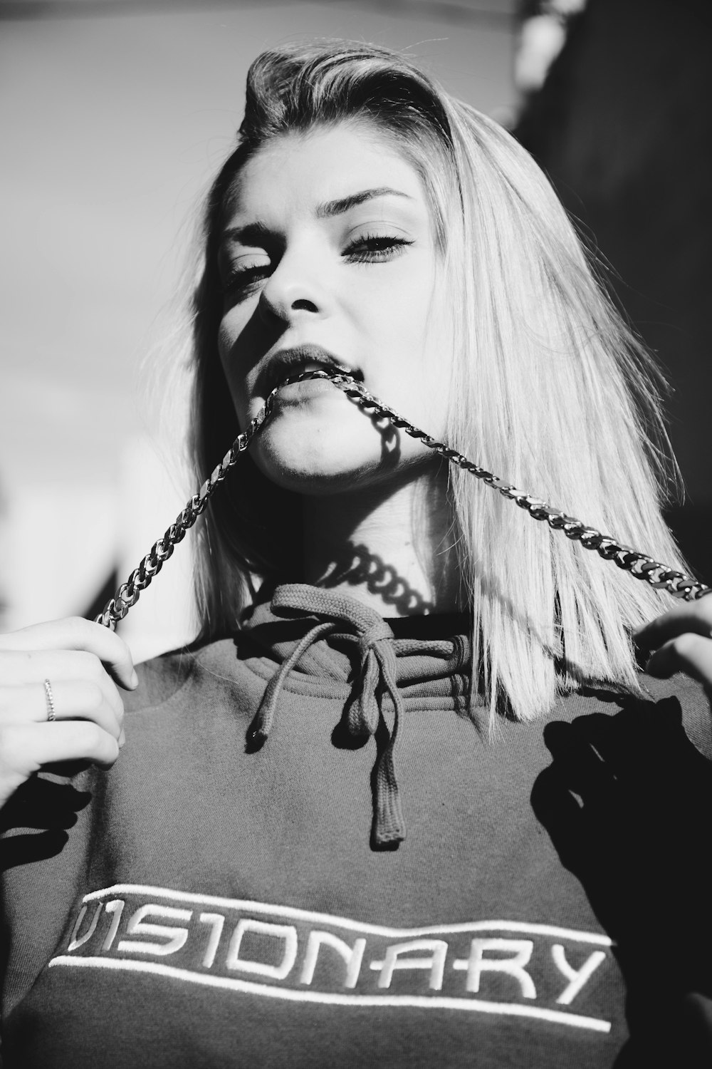 grayscale photography of woman biting rope