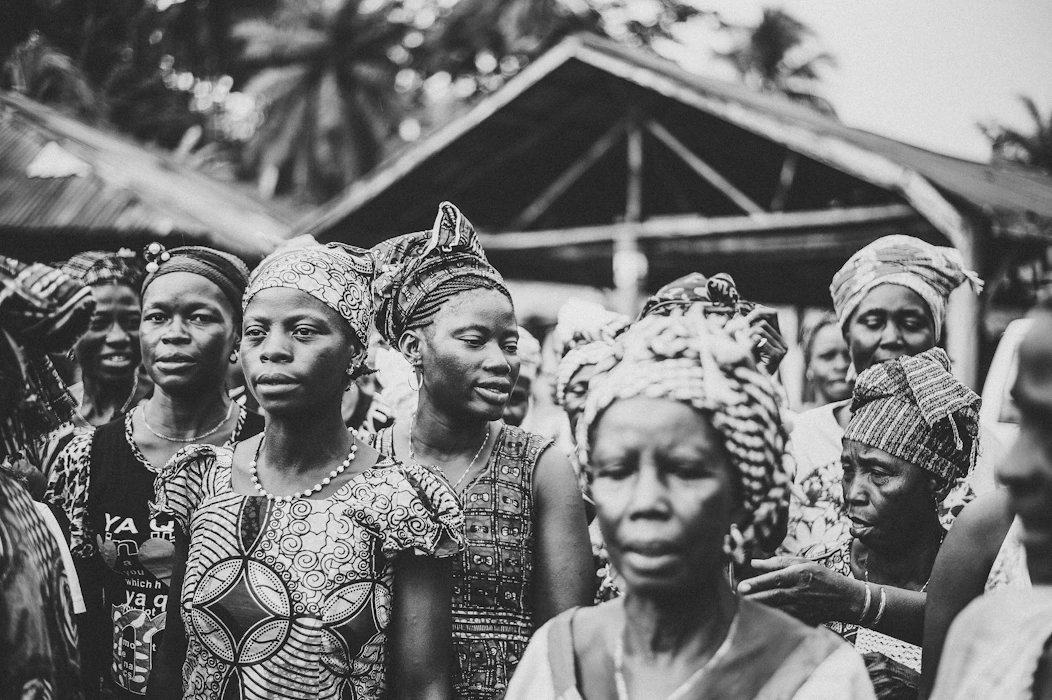 Community members gathered together outdoors — a visual nod to the Igbo women who used the written petition to make their voices heard during the colonial era