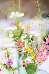 A vibrant arrangement of fresh flowers in a modern vase, showcasing lush greenery and colorful blooms.