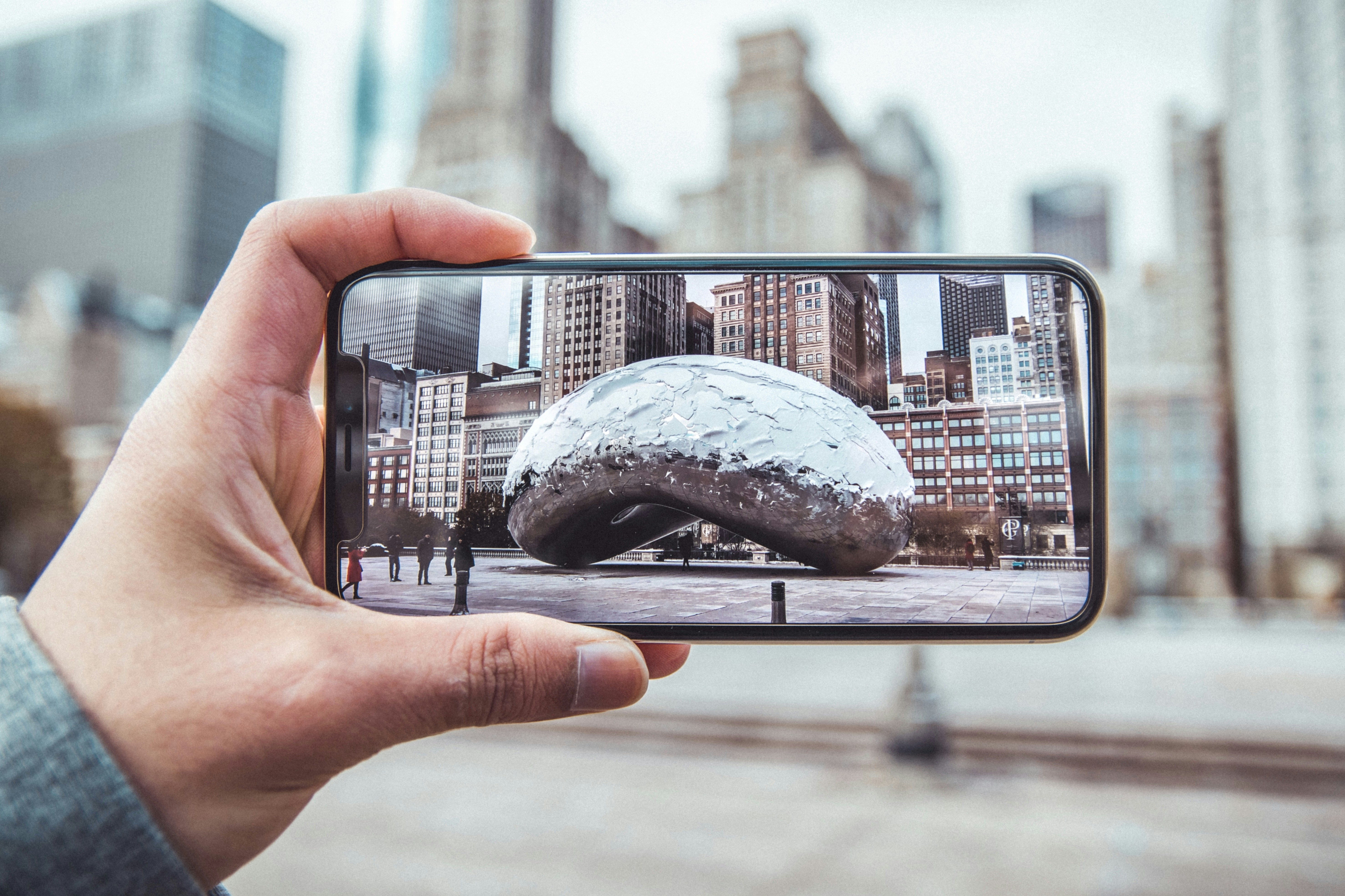 Person mit Smartphone und Kompendium-Foto