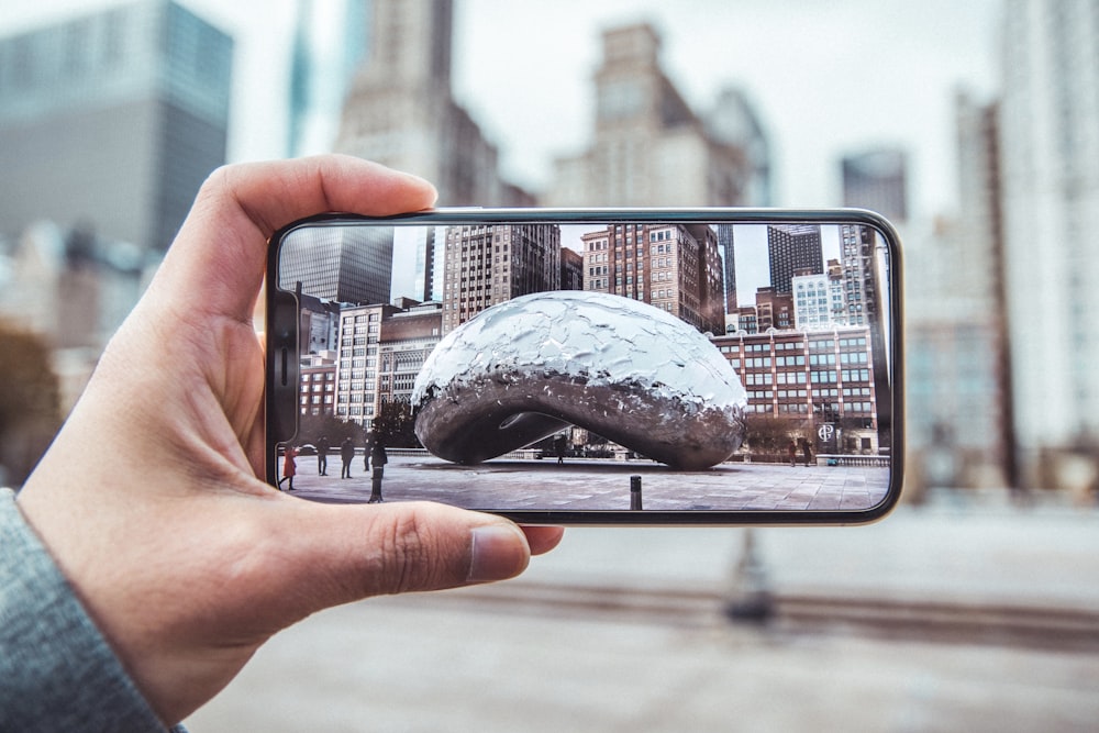 person holding smartphone showing compendium photo