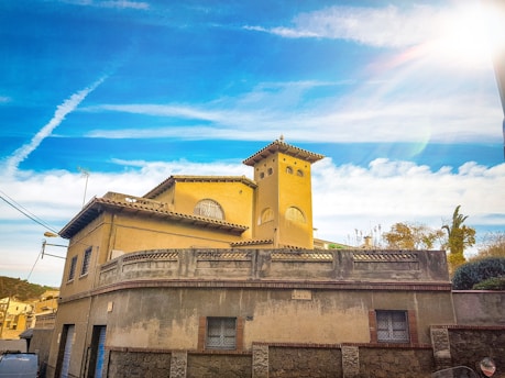 A professional inspecting a sunny Spanish villa, taking photos and notes.