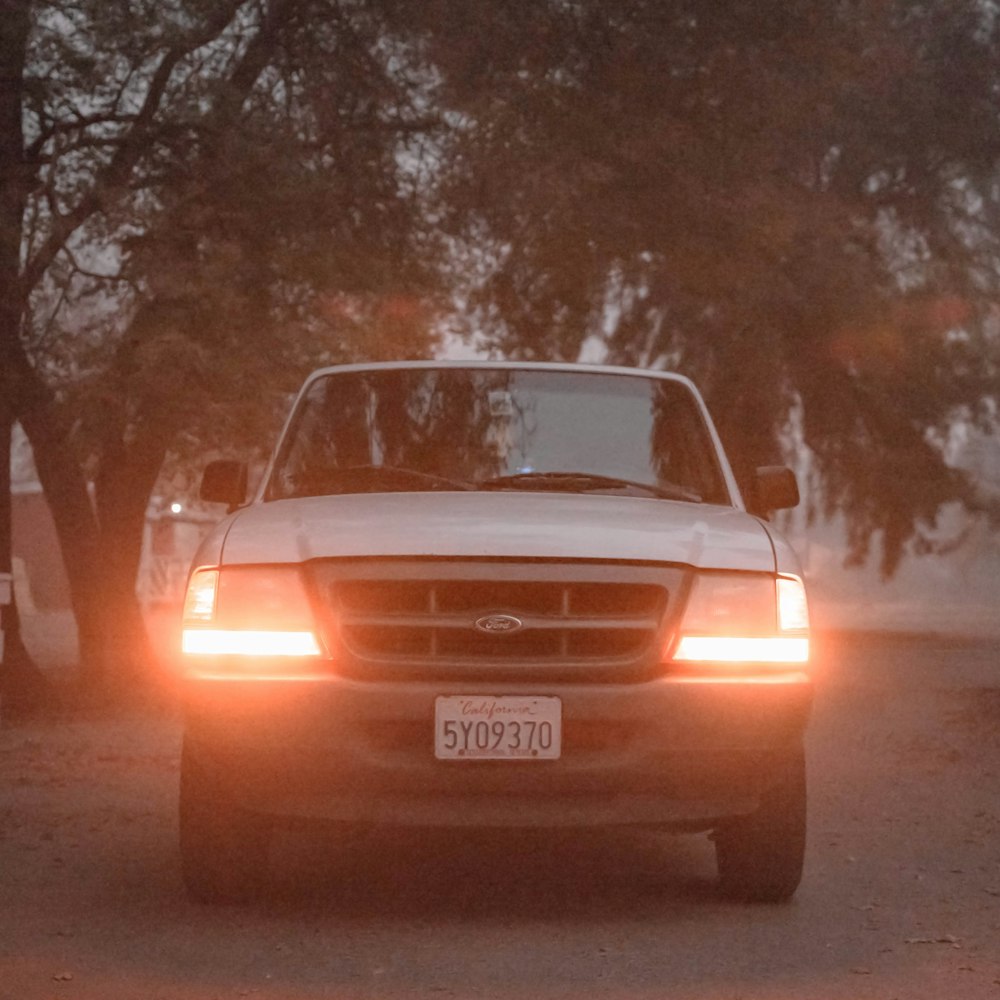 red Ford vehicle parked under tree