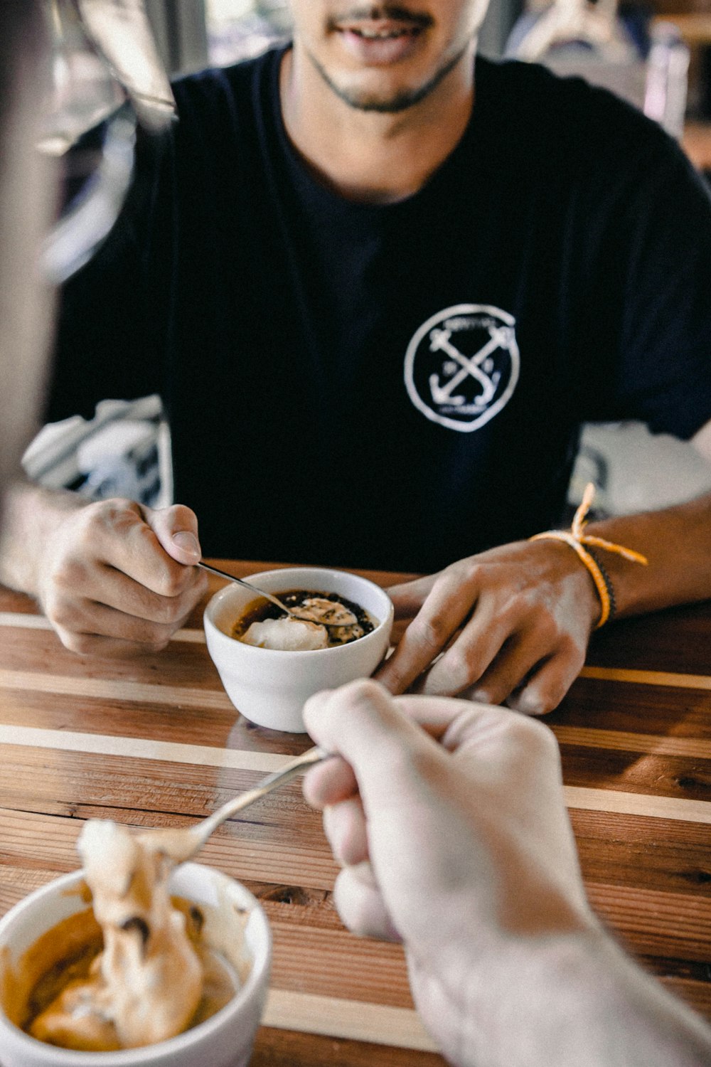 man sitting down in front of white ceramic teacup