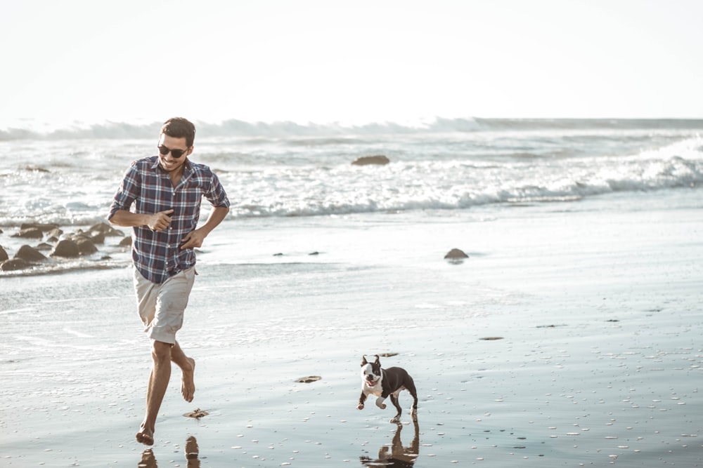 man wearing brown and white plaid dress shirt running on seashore