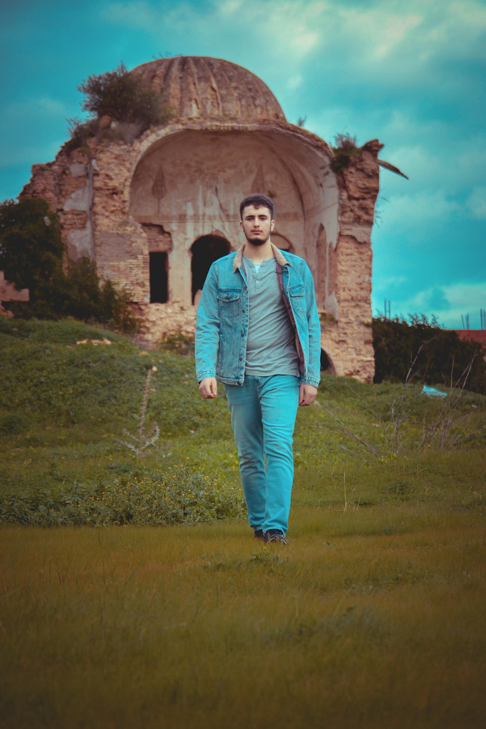 man in blue denim jacket and jeans walking during daytime