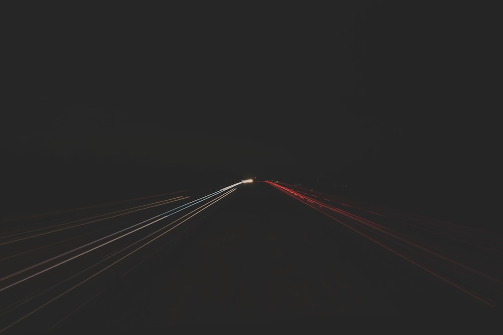 time lapse photography of passing cars on road