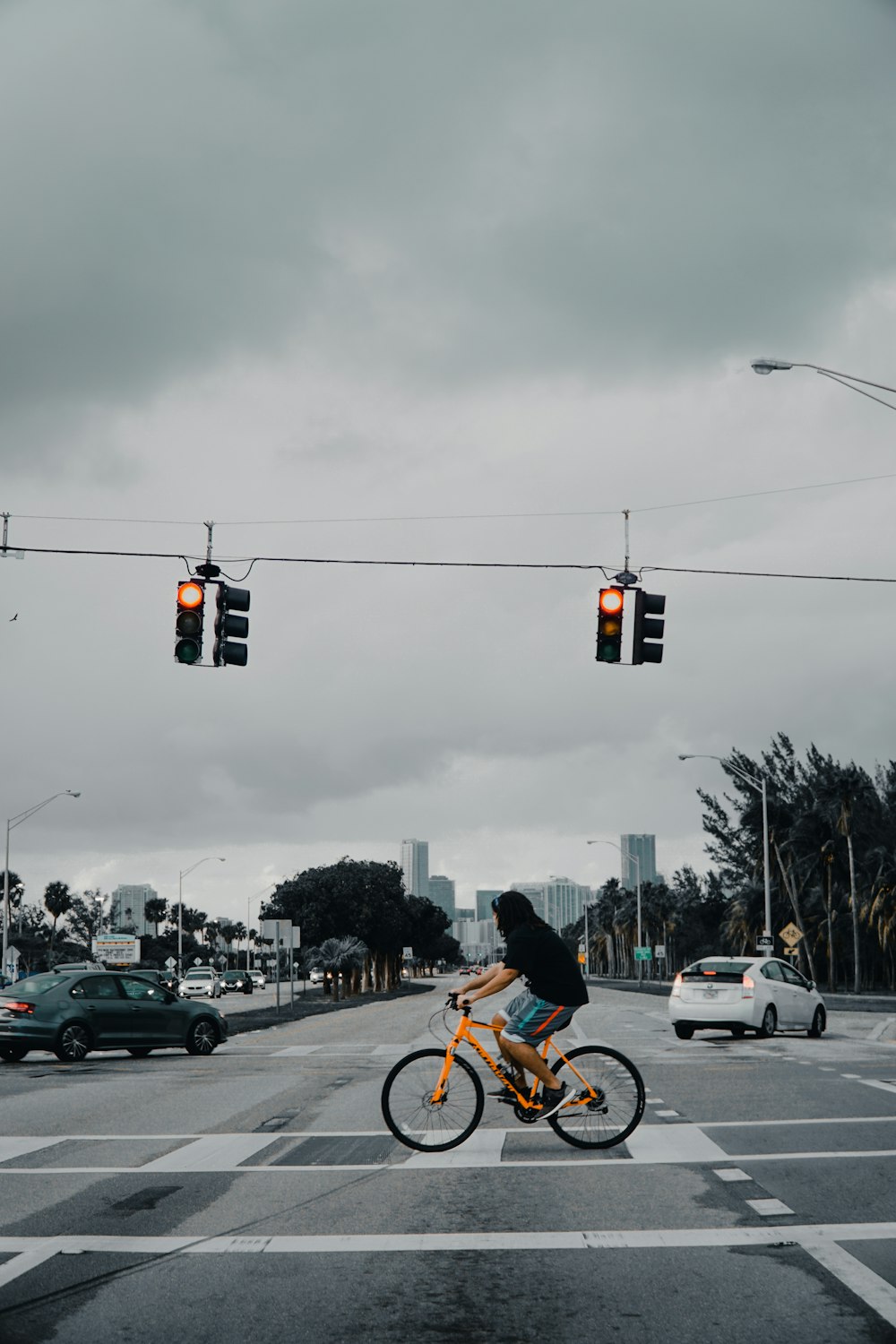 アスファルト道路で黄色い自転車を鳴らす男